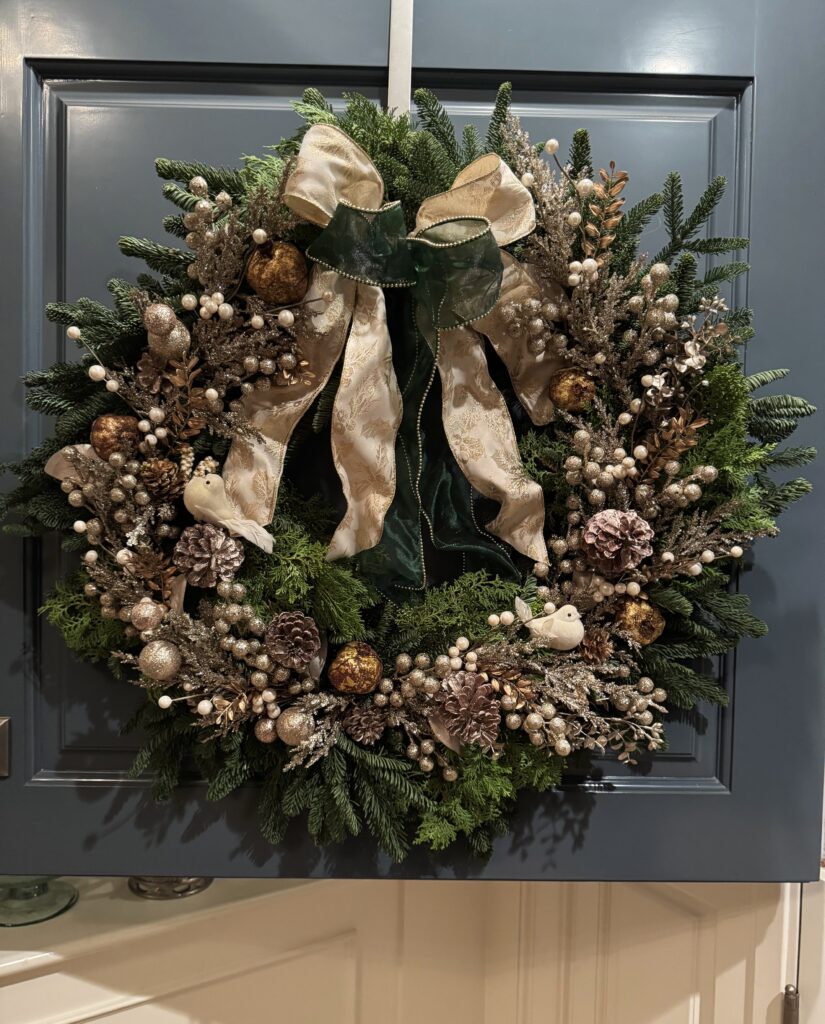 Champagne Holiday wreath displayed on a front door with frosted botanicals, pearl berries, white birds, and elegant champagne-gold accents.